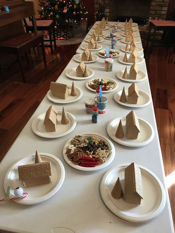 a long table is set up with paper plates and desserts on it for a holiday party