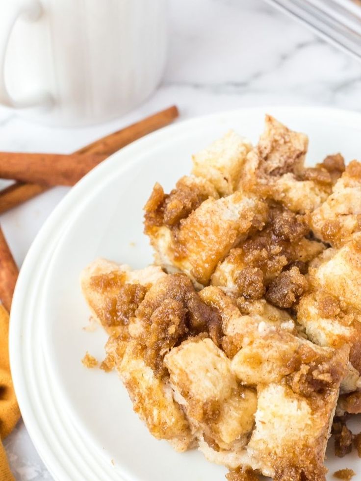 a close up of a plate of food on a table with cinnamon sticks and coffee