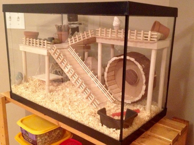 a large fish tank filled with lots of sand and water next to a wooden shelf