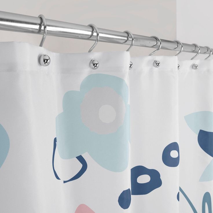 a shower curtain with blue and pink flowers on it's side hanging from a metal rod