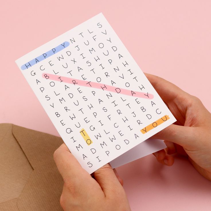 a person holding a piece of paper with letters on it