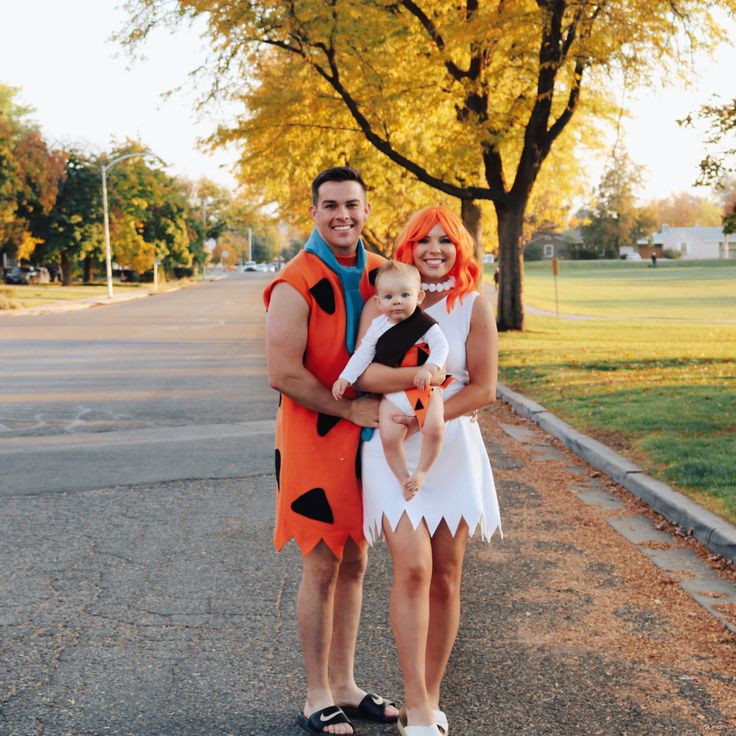 a man and woman dressed up as flint and the flintstones pose for a photo