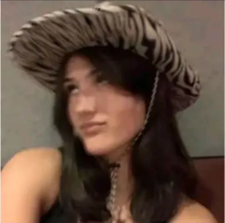 a woman wearing a zebra print hat while sitting down