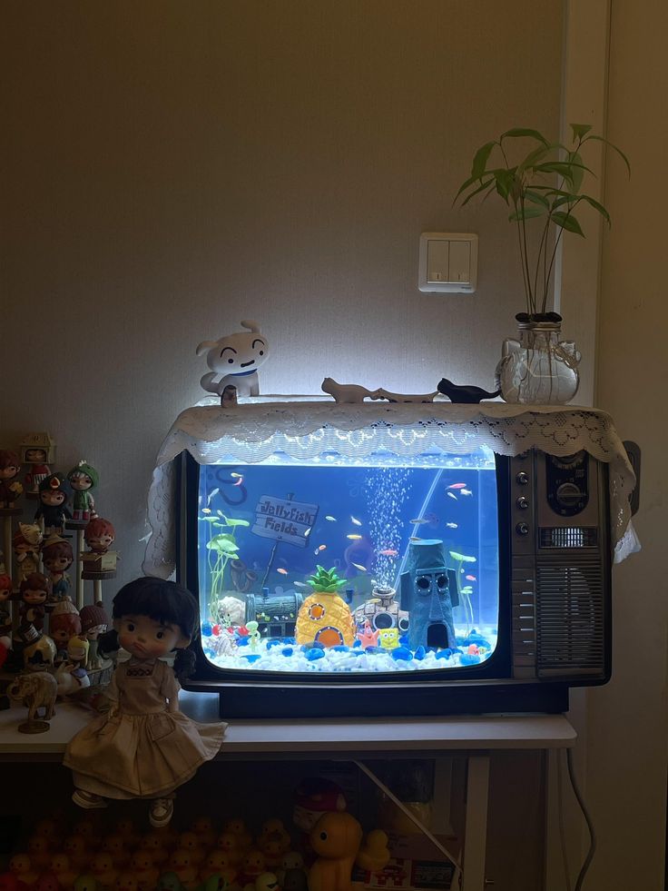 there is a small fish tank on top of the tv set in front of it