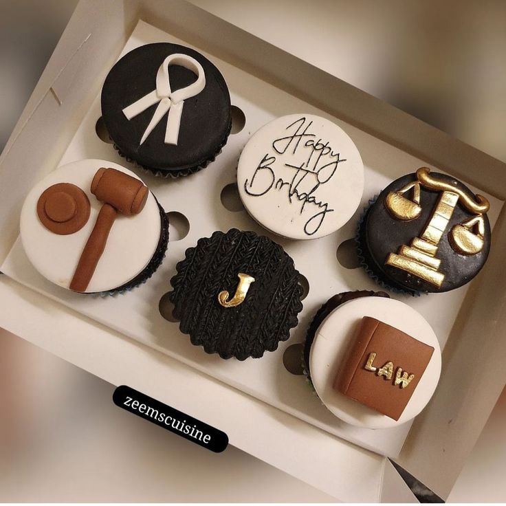 a box filled with decorated cupcakes in the shape of law and justice symbols