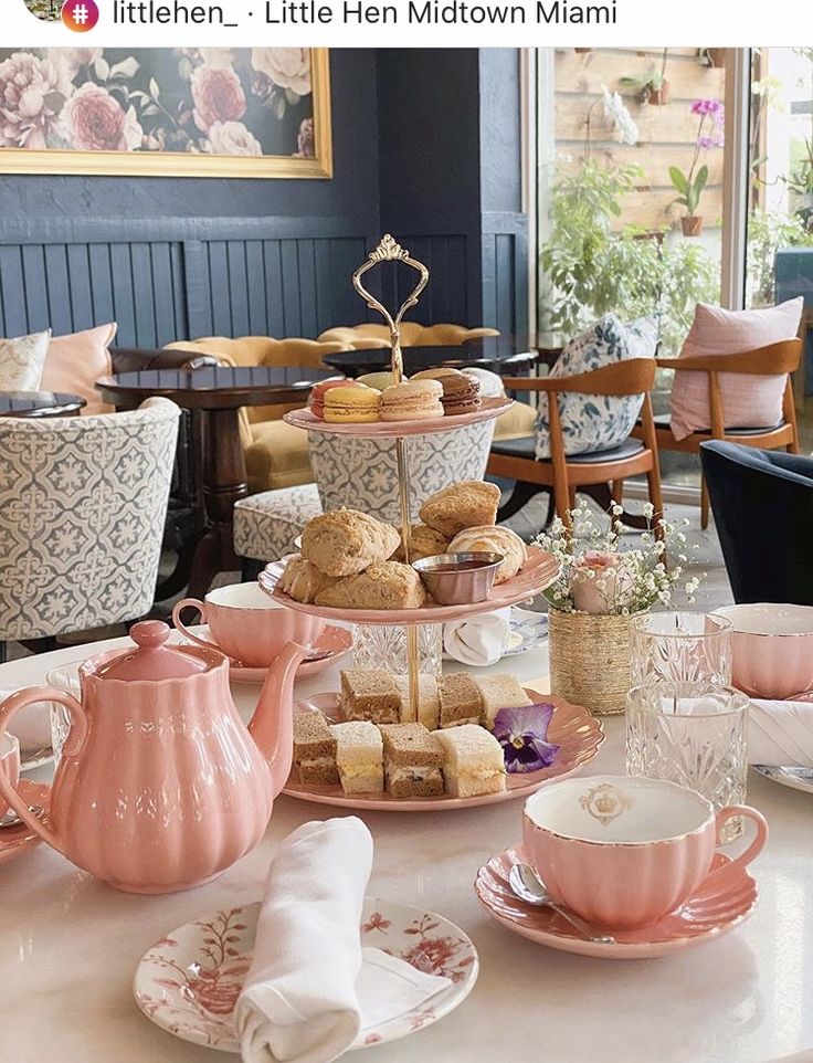 a table topped with plates and cups filled with food next to a tea pot on top of a table