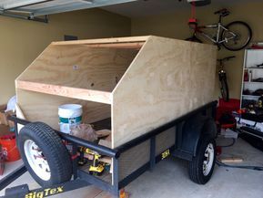 a bike is parked in the garage next to a cart that has been built into it