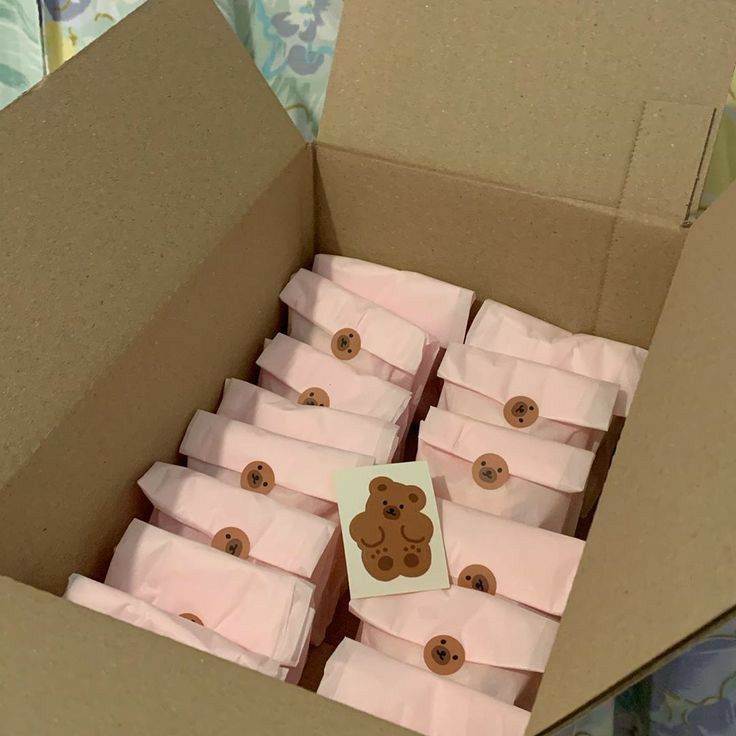 a box filled with lots of pink paper wrapped in brown teddy bear magnets on top of each other