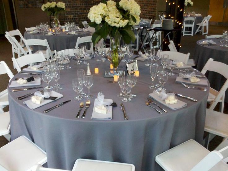 the table is set with white flowers and place settings for an elegant dinner or reception