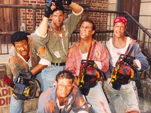 a group of men standing next to each other holding camera equipment in front of a brick building