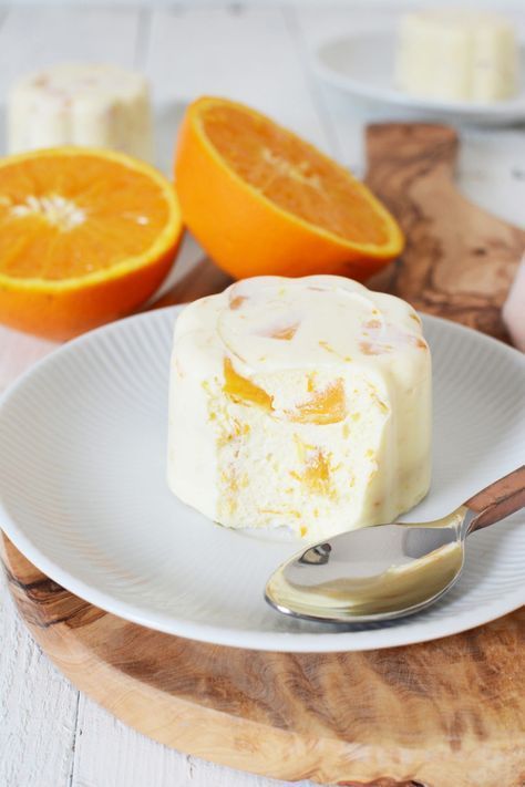 a piece of cake sitting on top of a white plate next to an orange slice