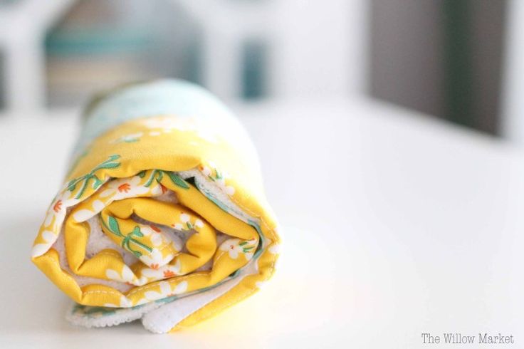 a rolled up yellow and white blanket sitting on top of a table