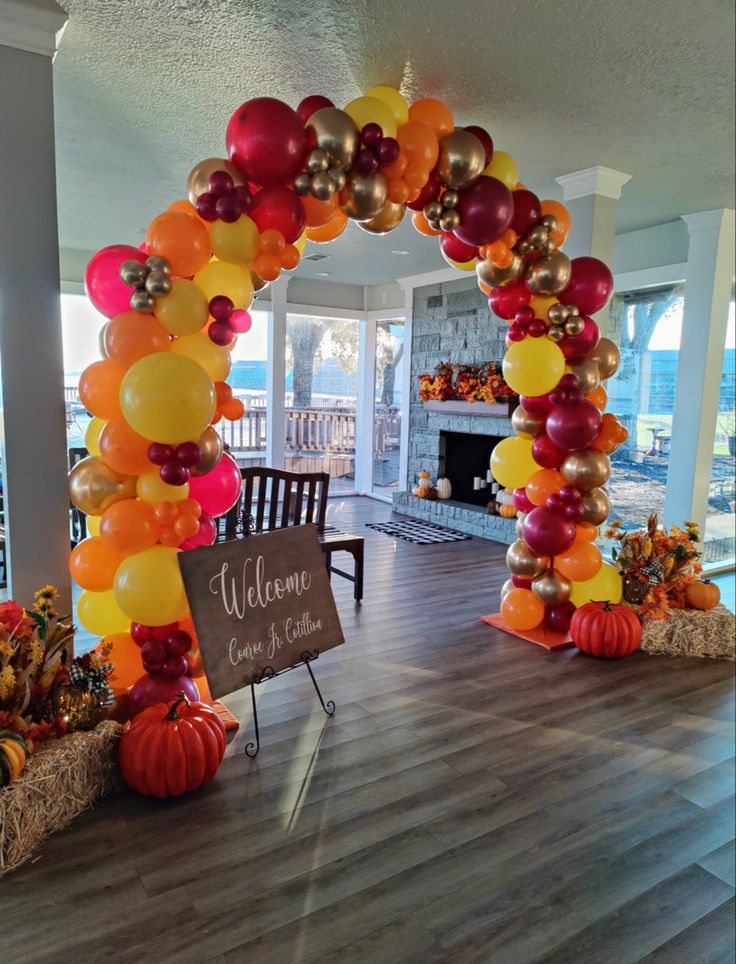 an entrance decorated with balloons and pumpkins for a fall wedding or bridal party