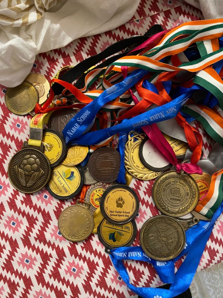 a pile of medals sitting on top of a red and white checkered table cloth