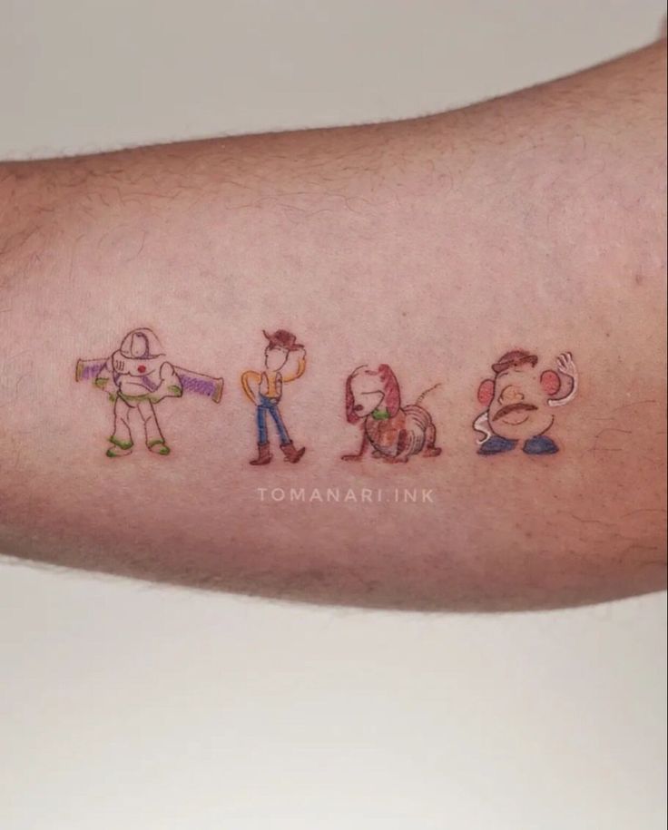 a man's arm with some cartoon characters on it and the word tomma ink