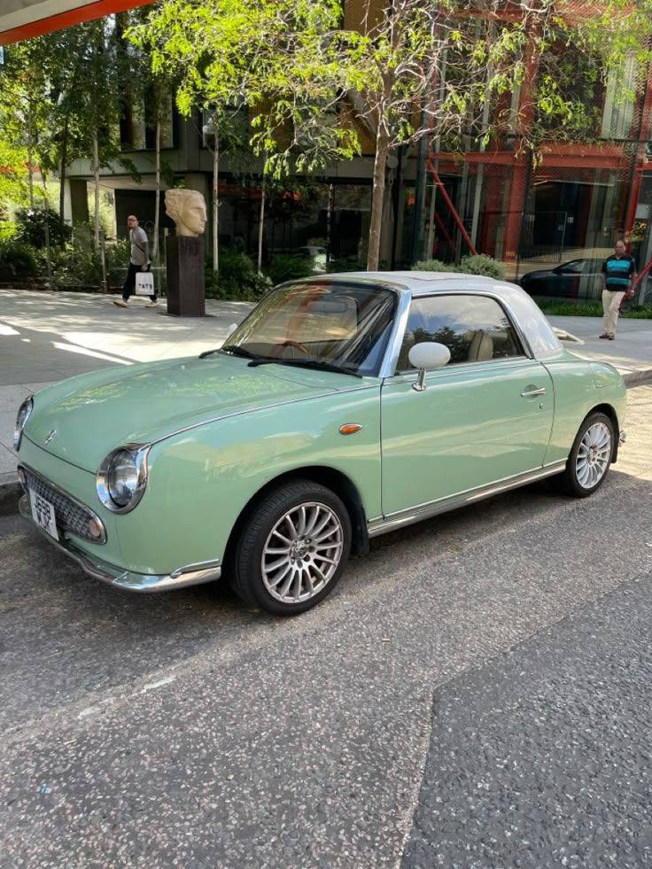 an old green car is parked on the street