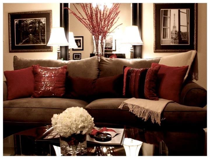 a living room with couches, lamps and pictures hanging on the wall above them