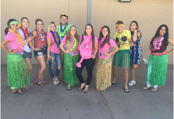 a group of people standing next to each other wearing hula skirts and leis