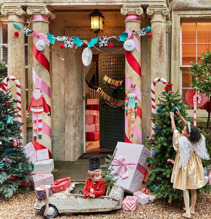 there is a small child that is sitting in a wagon with presents on the ground