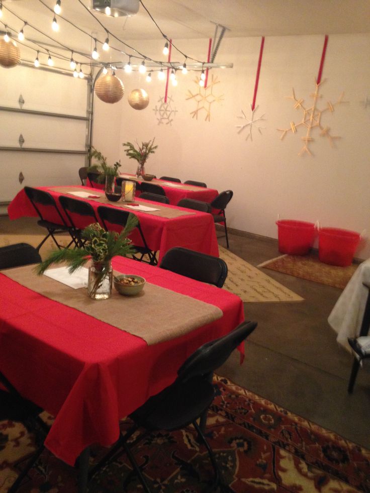 a dining room with red table cloths and lights hanging from the ceiling above it