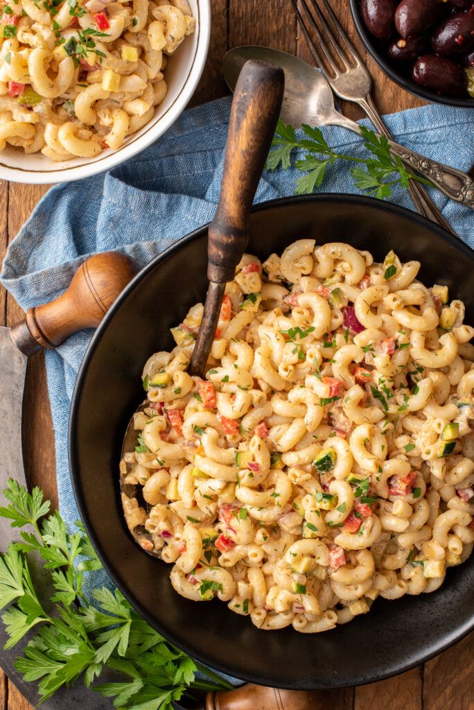 a skillet filled with macaroni and cheese on top of a wooden table