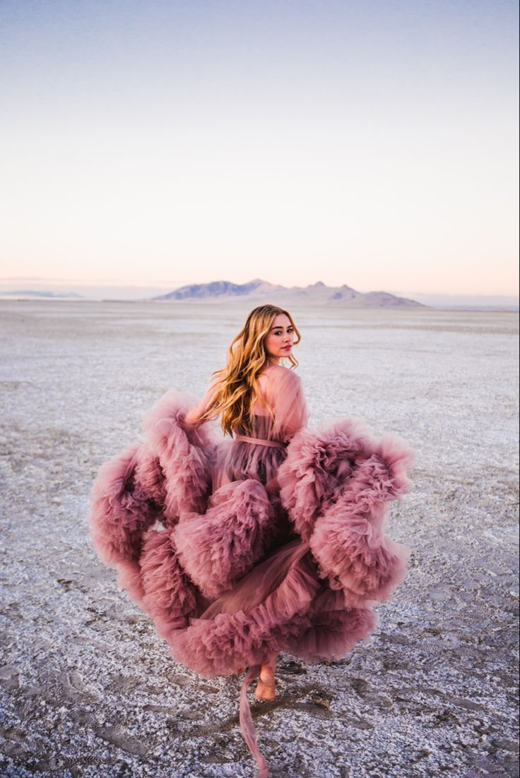 a woman standing in the middle of an empty field