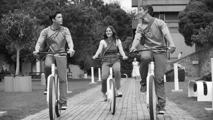 three people riding bikes on a brick walkway