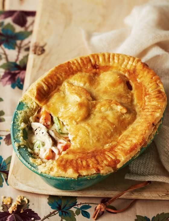 a close up of a pie in a bowl on a table with a flowered cloth