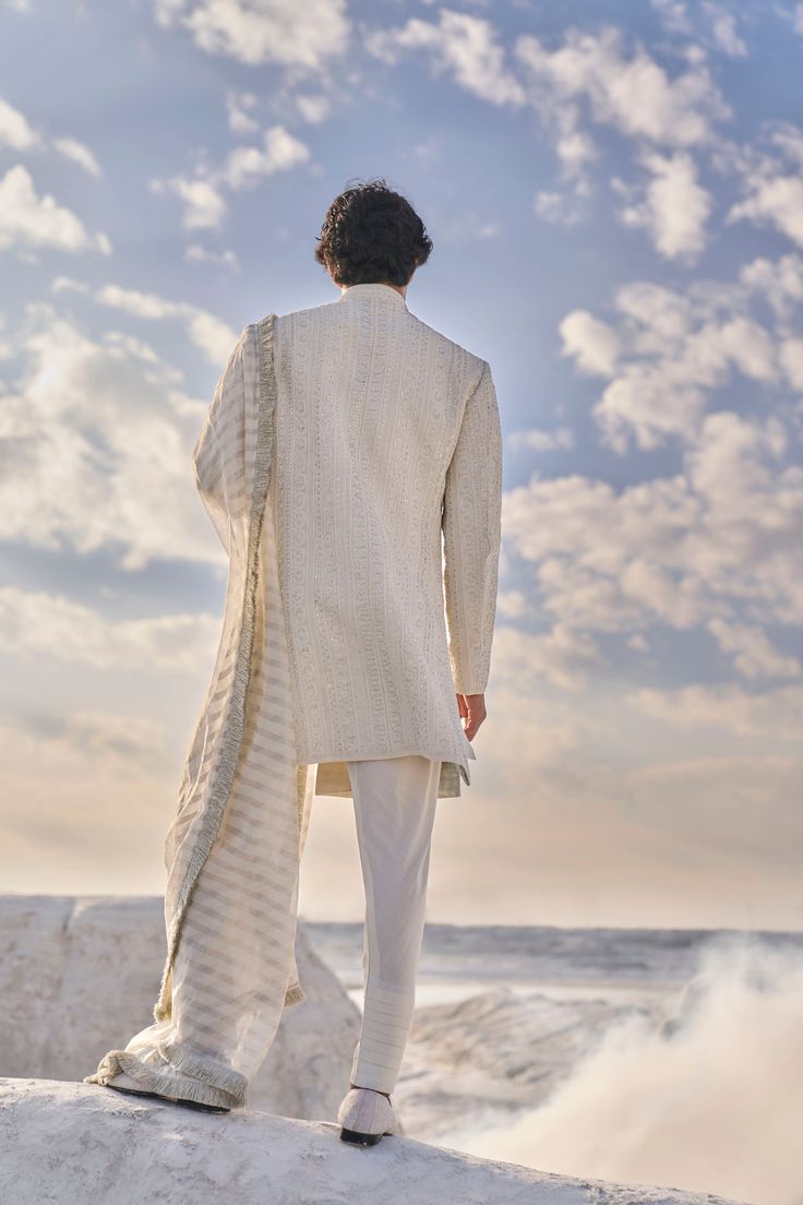 This sherwani set features all over intricate dori embroidery highlighted in delicate pearl and gold sequin. The ensemble is paired with an off-white cotton silk kurta and churidar.From Seema Gujral's Elements collection. DELIVERY TIMEPlease allow 6-8 weeks for your outfit to arrive. FABRIC DETAILSSherwani, Raw Silk Kurta, Cotton Silk Dupatta, Chanderi Silk Chudidar, Cotton Silk Professional cleaning only. Cotton Silk Sherwani With Chikankari Embroidery, White Cotton Silk Bandhgala With Resham Embroidery, Transitional White Cotton Silk Bandhgala, Designer Traditional Drape Off White Kurta, Ceremonial Cotton Silk Sherwani With Resham Embroidery, Bollywood Cotton Silk Sherwani With Chikankari Embroidery, Cotton Silk Bandhgala For Ceremonial Eid, Cotton Bandhgala With Resham Embroidery In Traditional Drape, Festive Cotton Silk Bandhgala With Traditional Drape