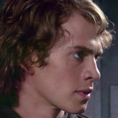 a close up of a young man wearing a star wars shirt and looking off to the side