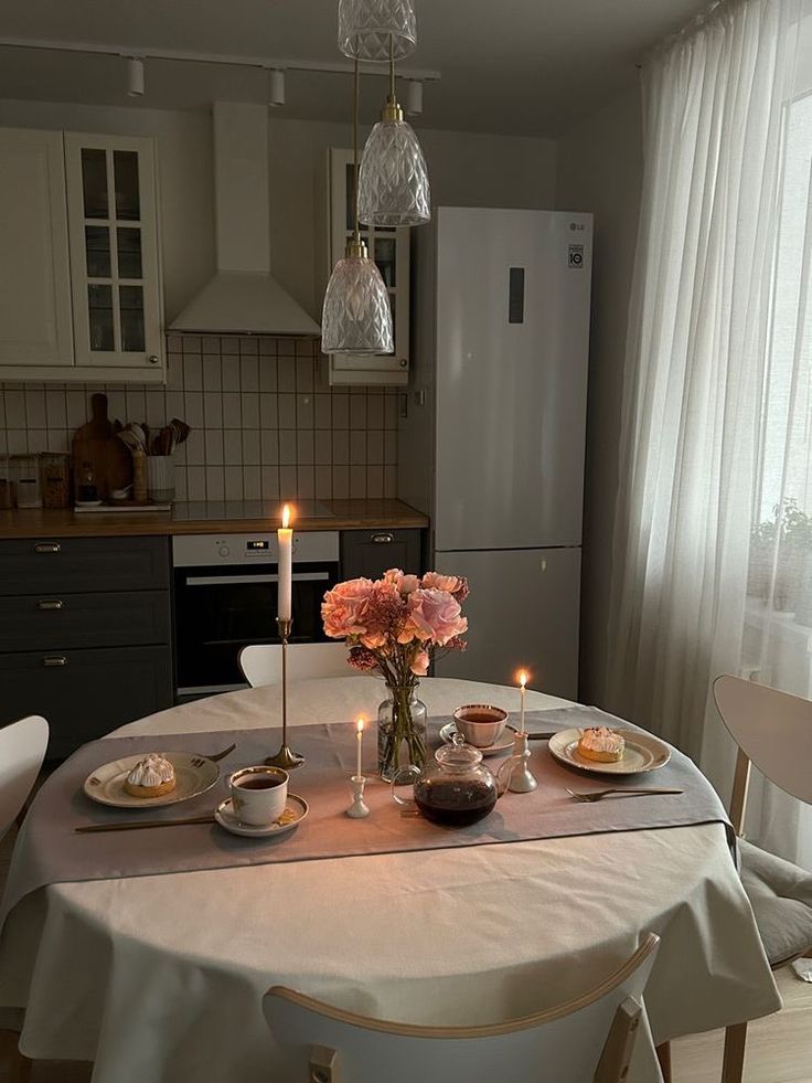 a dining room table is set with plates and candles for two people to enjoy the meal