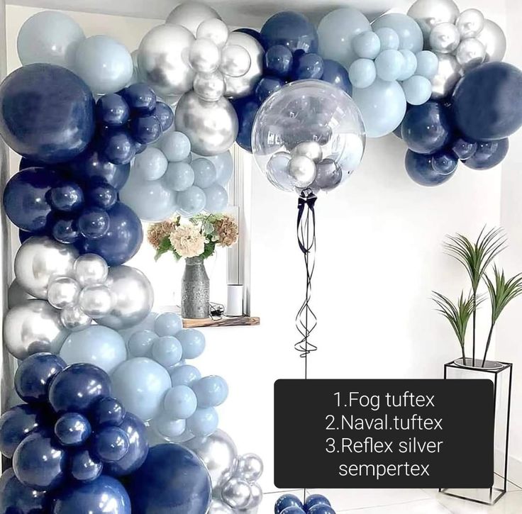 blue and white balloons are hanging from the wall in front of a vase with flowers