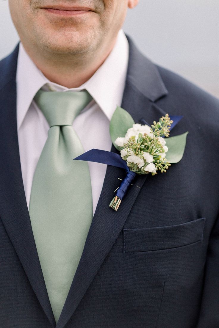 a man in a suit and tie with a boutonniere on his lapel