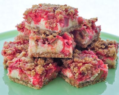 several pieces of dessert sitting on top of a green plate with crumbled toppings