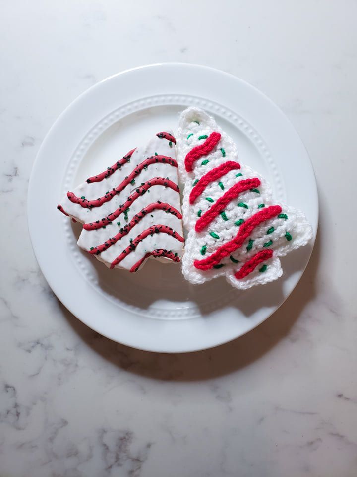 two decorated cookies sitting on top of a white plate