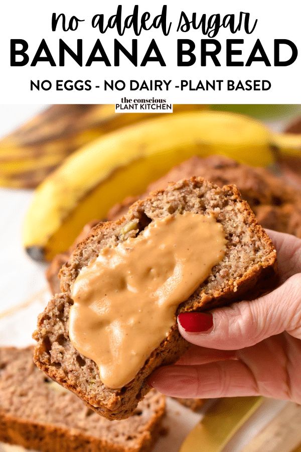 a person holding a banana bread with peanut butter on top and bananas in the background