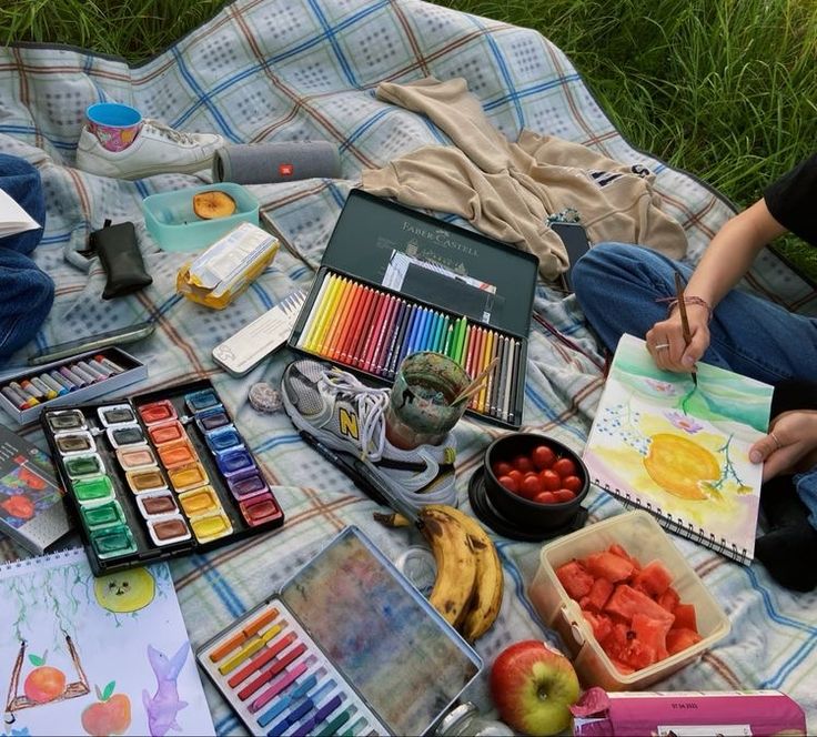 a person sitting on a blanket with some art supplies