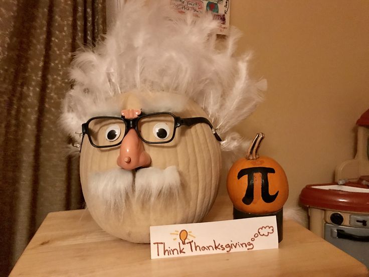 a pumpkin with a man's face and glasses on it next to a sign that says thank thanksgiving