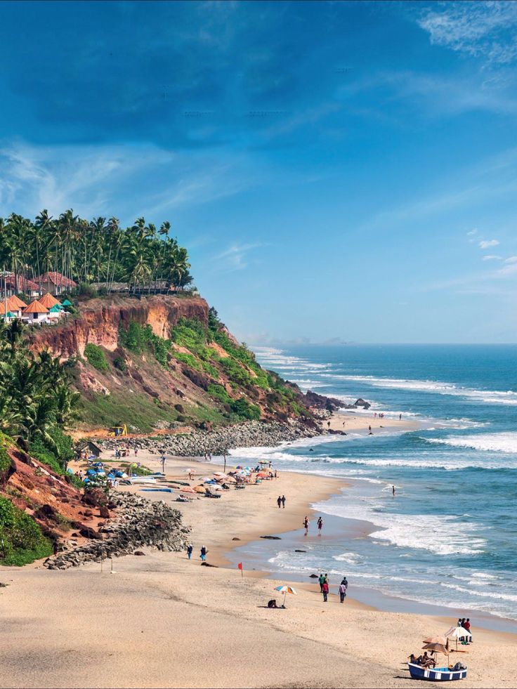 people are on the beach and in the water near some cliffs with houses on them