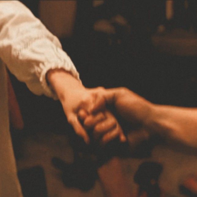 two people holding hands while standing next to each other