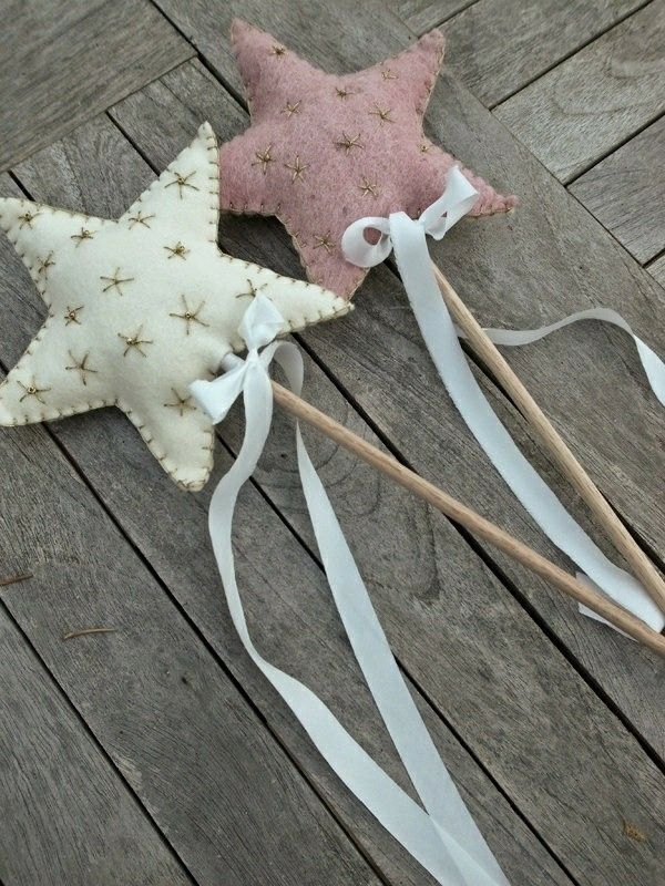 two small stars are on sticks with white ribbon around them and one has a pink star in the middle