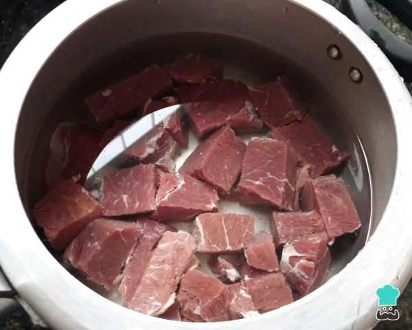 raw meat is being cooked in a pot