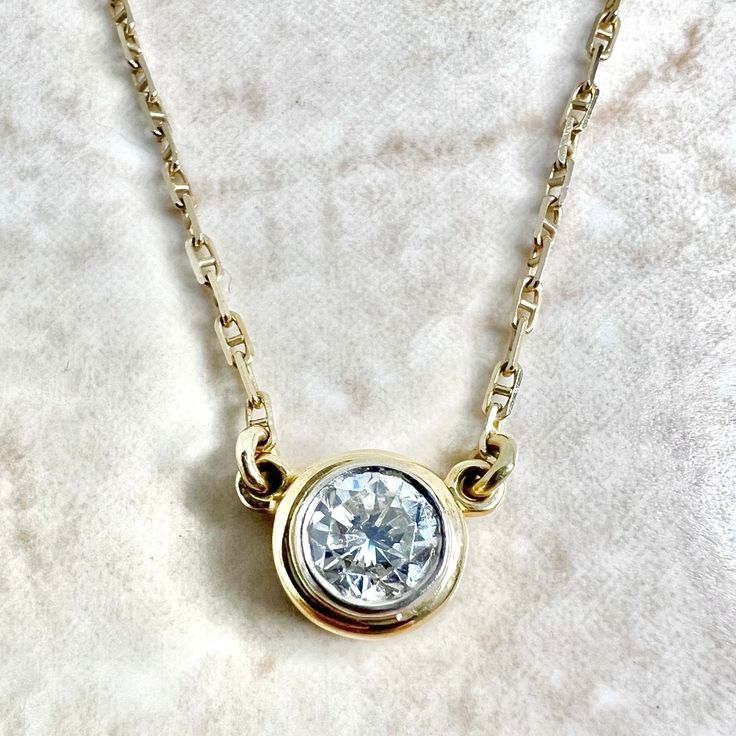 A spectacular vintage 14 karat yellow and white gold solitaire pendant necklace featuring a 5.25 mm natural round diamond weighing approximately 0.60 carat. It is G-H in color and VS2 in clarity. The necklace is 15 inches long. The bezel is 7.50 mm in diameter. The chain is 1.25 mm thick and equipped with a safety snap tab. Weighs 3.42 grams. Stamped 14K. Birthstone: April. Condition: Very good. Light scratches and wear throughout metal. - 14 day return policy, no questions asked. - Free insured Vintage Yellow Gold Diamond Necklace, Classic Round Stone Diamond Necklace, Classic Diamond Necklace With Round Single Diamond, Classic Diamond Necklace With Single Round Stone, Timeless Yellow Gold Solitaire Necklace With Round Stone, Classic 14k Yellow Gold Solitaire Necklace, 14k Gold Solitaire Necklace For Anniversary, Classic Yellow Gold Diamond Necklace With Round Stone, 14k Gold Solitaire Necklace With Round Stone For Anniversary