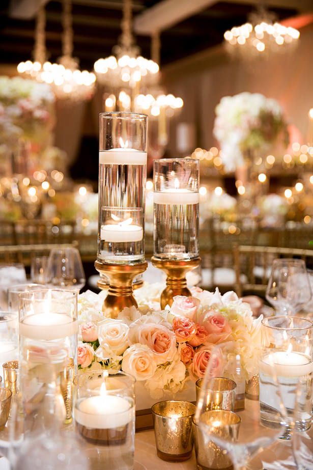 the centerpieces are filled with candles, flowers and votive glass vases