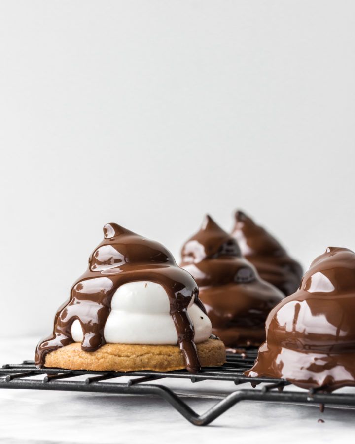 chocolate covered desserts sitting on top of a cooling rack