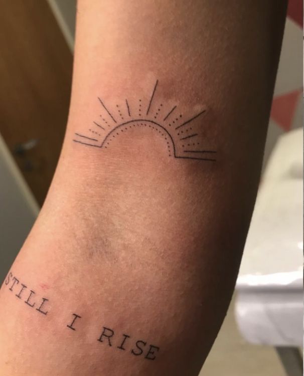 a person with a tattoo on their arm that says fill i rise and the sun is rising