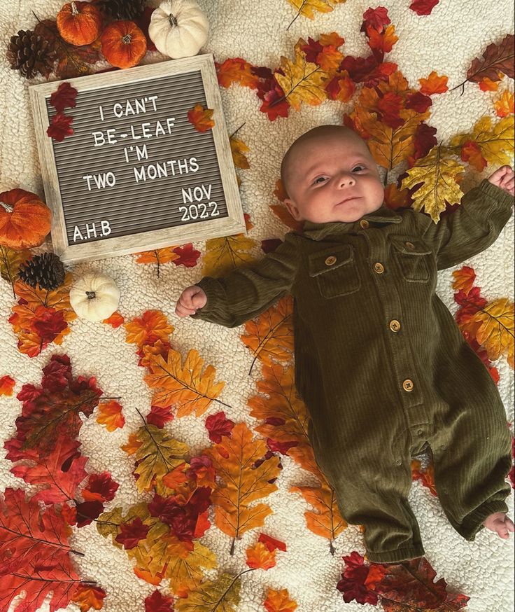 a baby is laying down next to a sign that says i can't be near two months ago