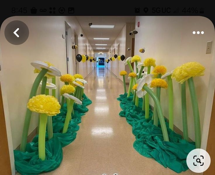 the hallway is decorated with yellow flowers and green ribbons on both sides, along with white walls