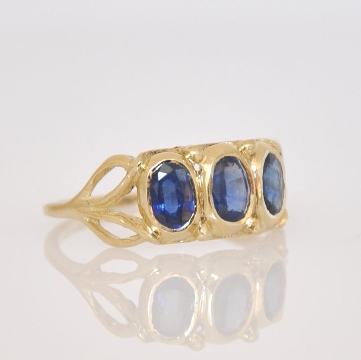 "A beautiful handmade gold 3 Sapphire gold ring for a woman. This solid gold and Sapphire ring is all hand made engraved by me in lost wax technique. The ring is 14k solid gold all made as one single piece including the three stone bezels, in which three beautiful blue Sapphire stones are set and the two leaves on each side of the ring. The ring has a vintage style look that resembles a royal Sapphire ring. This blue Sapphire and gold ring will surly get attention to your finger. I am certain yo Gold Hand Forged Sapphire Ring, Hand Forged Gold Sapphire Ring, Hand Forged Blue Sapphire Ring For Anniversary, Anniversary Blue Hand Forged Sapphire Ring, Gold Sapphire Rings Hand Forged, Handmade Oval Sapphire Ring In 14k Gold, Elegant Handmade Yellow Gold Sapphire Ring, Heirloom Gold Sapphire Ring With Three Stones, Heirloom Gold Three Stone Sapphire Ring