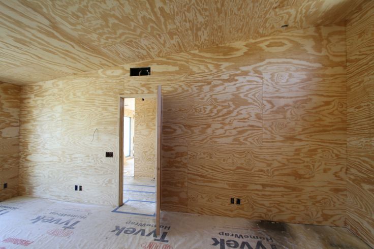 an unfinished room with plywood walls and flooring in the process of being installed